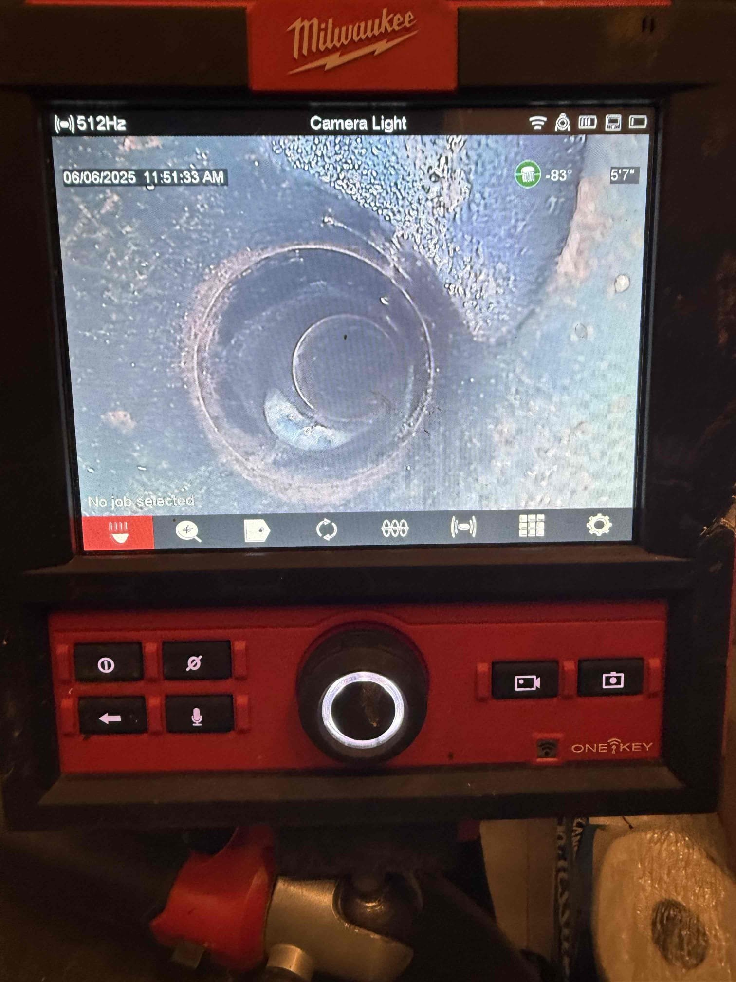 A Facilities Plumbing And Drain technician using video to scan the interior of a drain.
