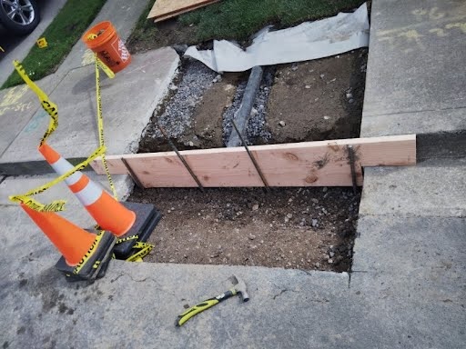 Facilities Plumbing And Drain digs a curb drain.