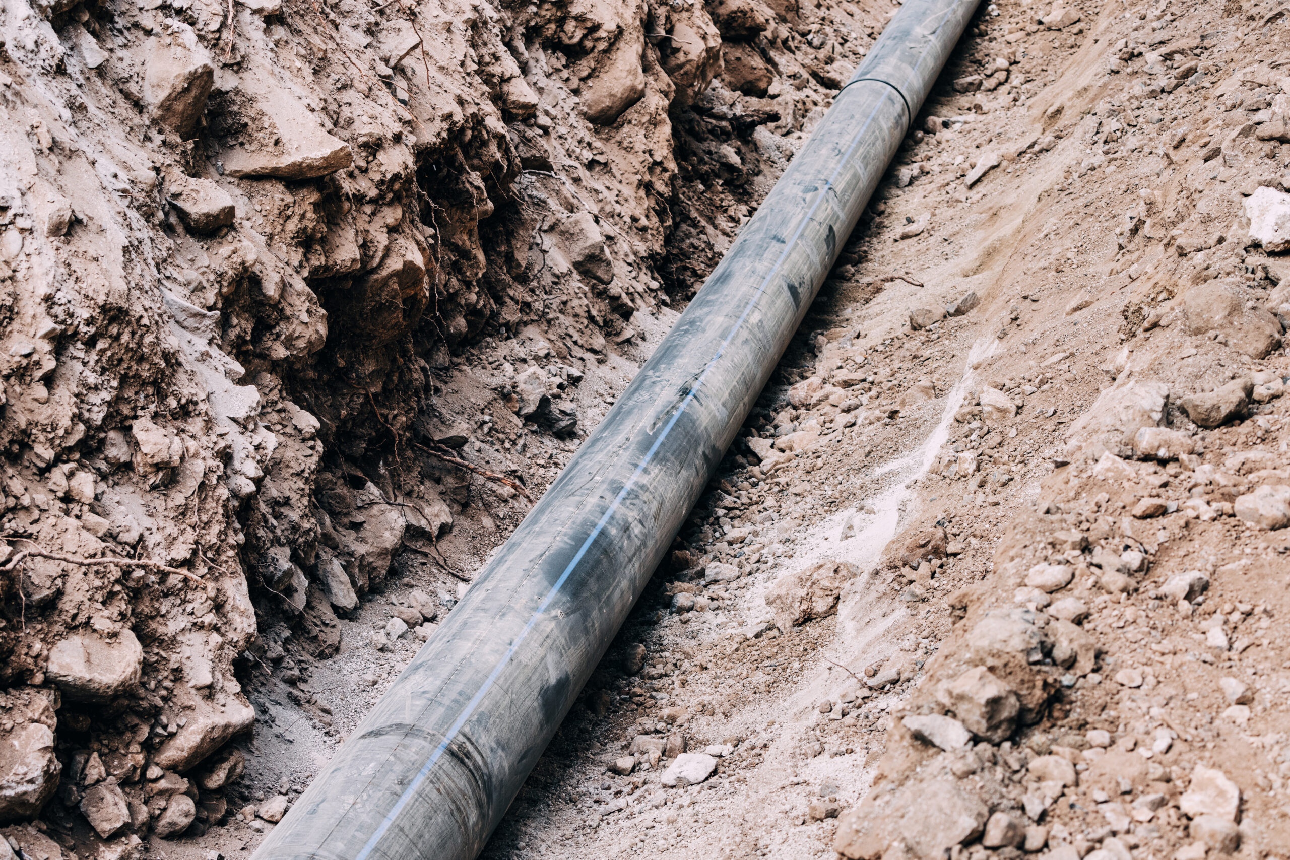 A black sewer line in a trench near a Palo Alto, CA business