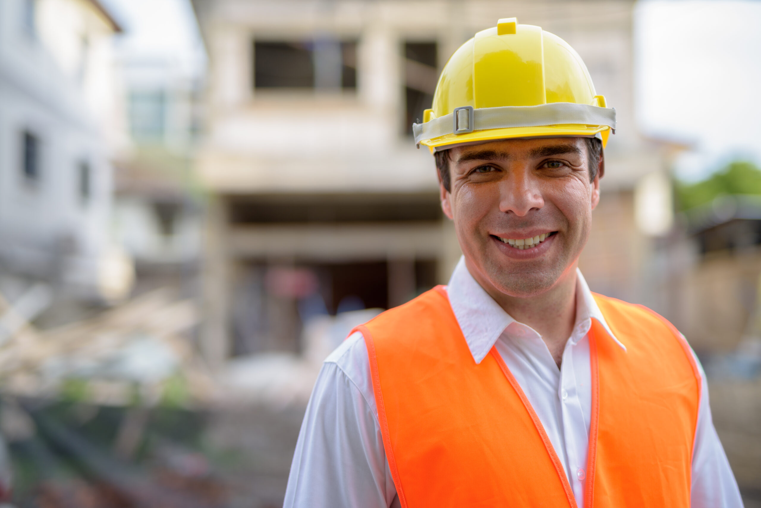 A plumber in a hard hat smiling as he works on a commercial sewer replacement project in Palo Alto, CA.
