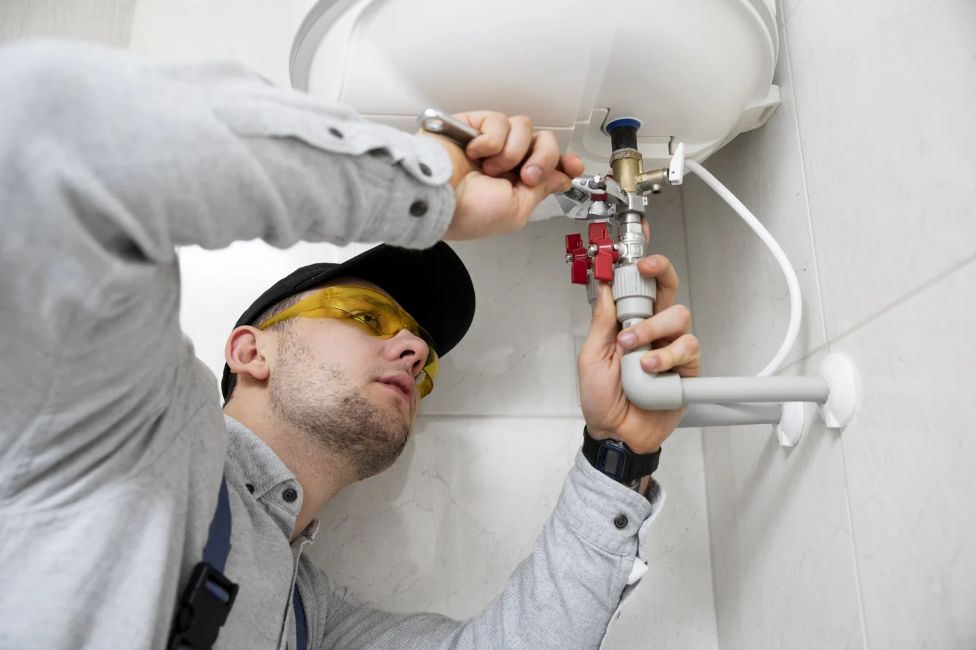 A plumber repairing a water heater in Alameda County, CA.