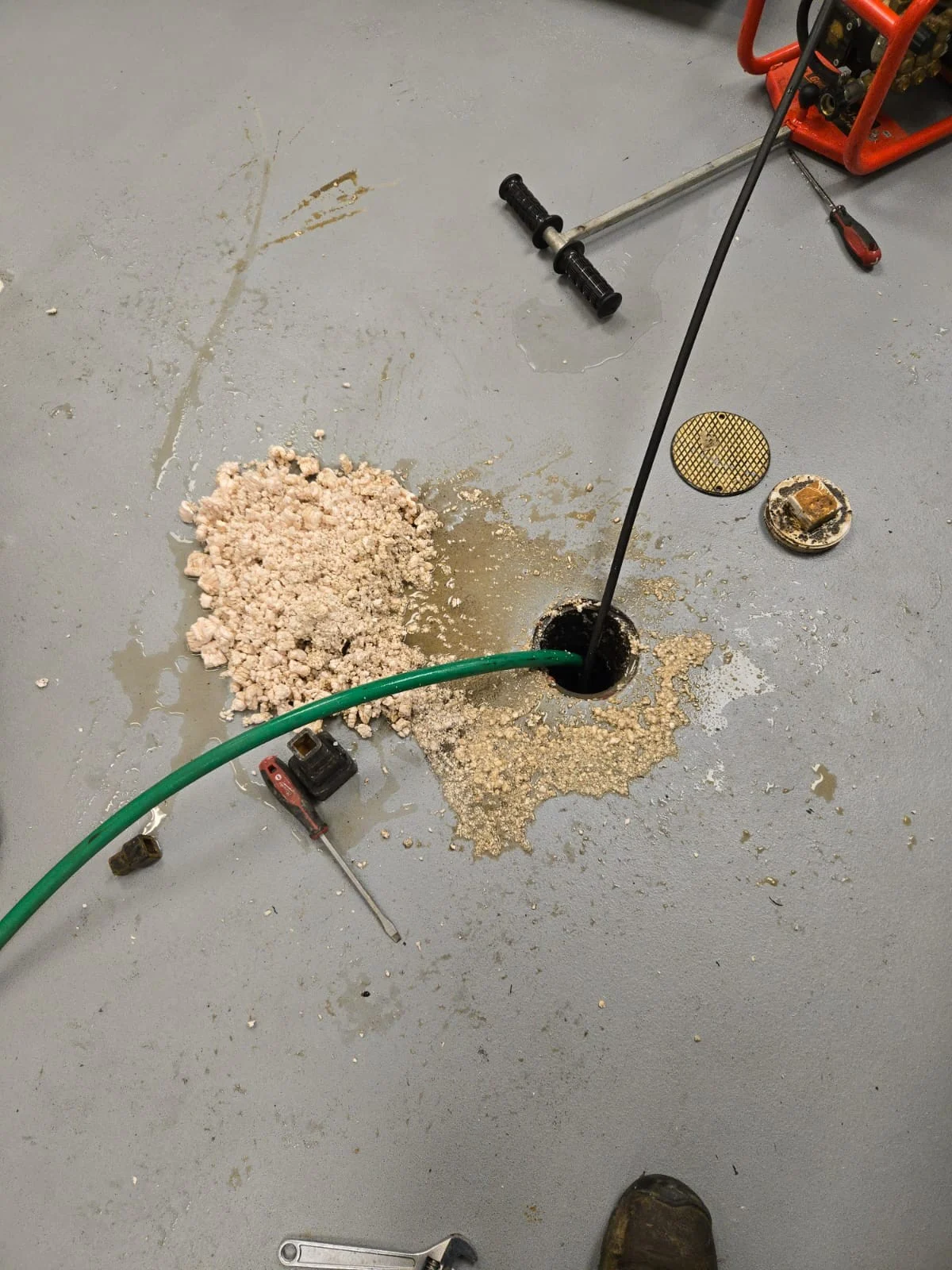 A burst black plumbing pipe is spraying water from a cracked joint during an active leak emergency.